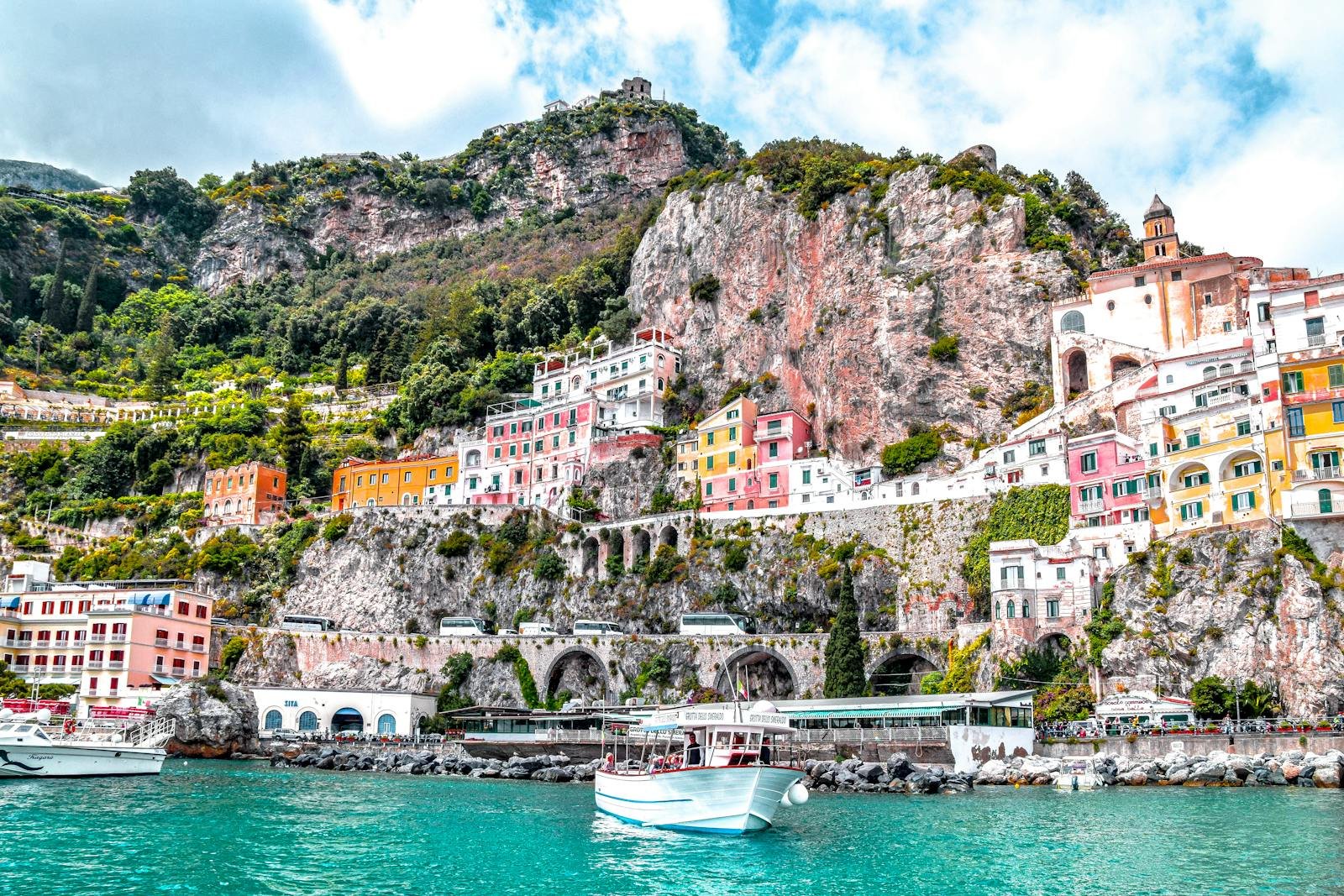 Colorful buildings on a rocky cliffside above the turquoise water in Amalfi, Italy, Amalfi, SA, Italy