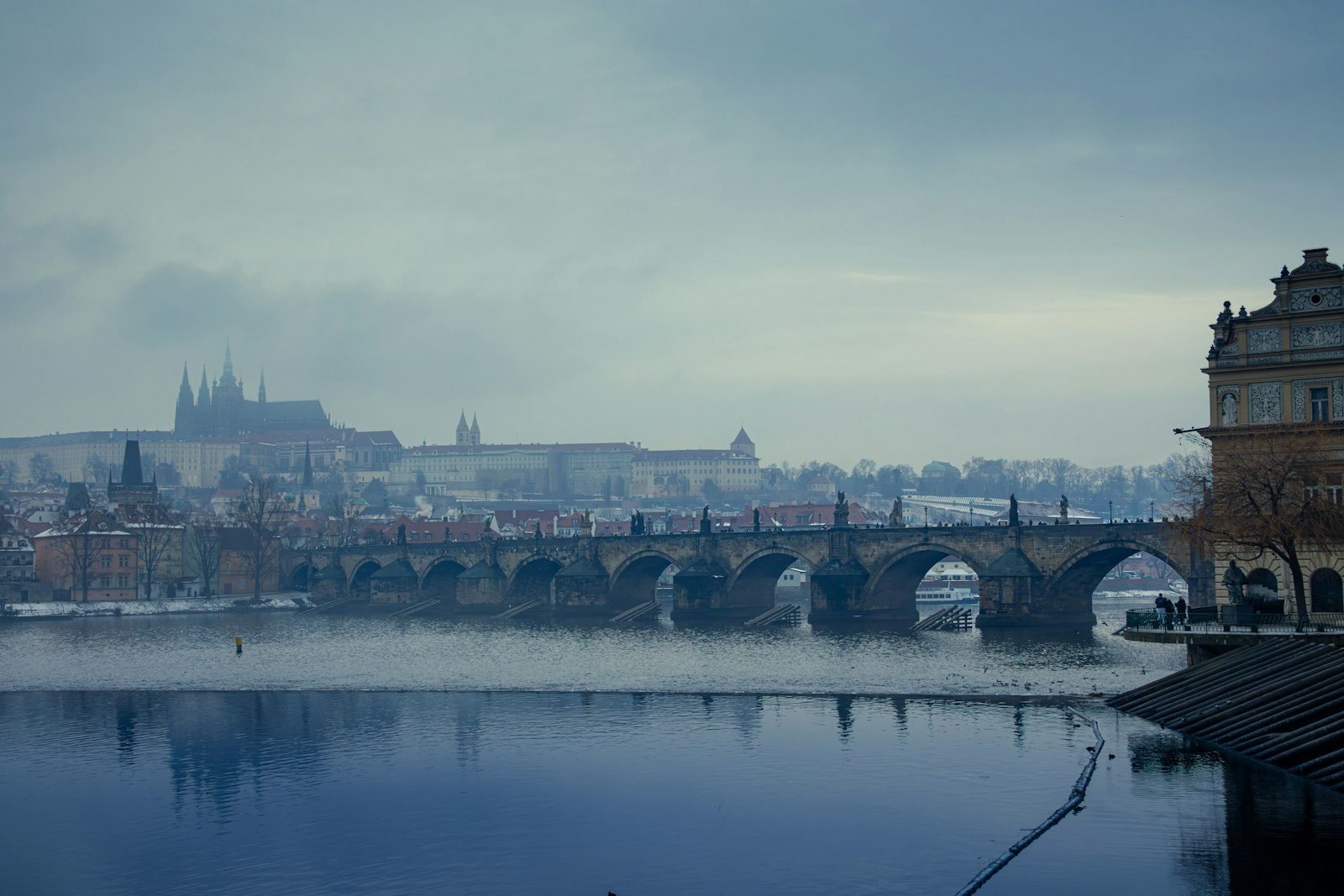 Charles Bridge over the Vltava River with Prague Castle in winter