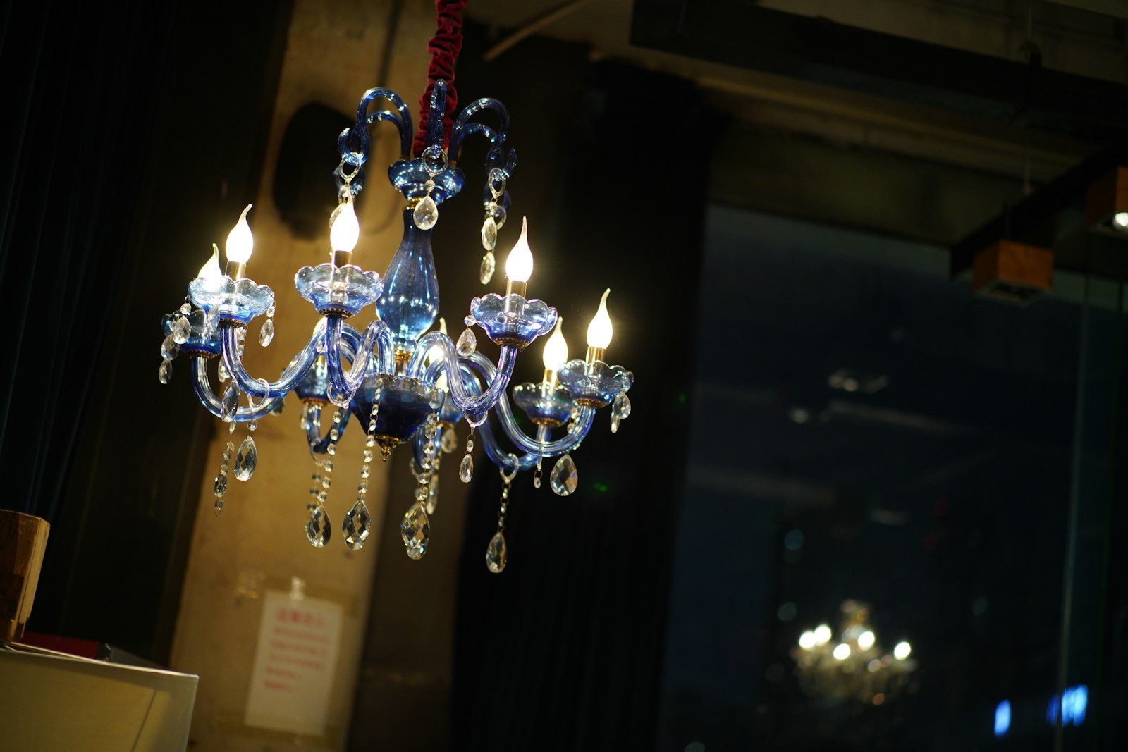 A blue crystal chandelier with lit bulbs