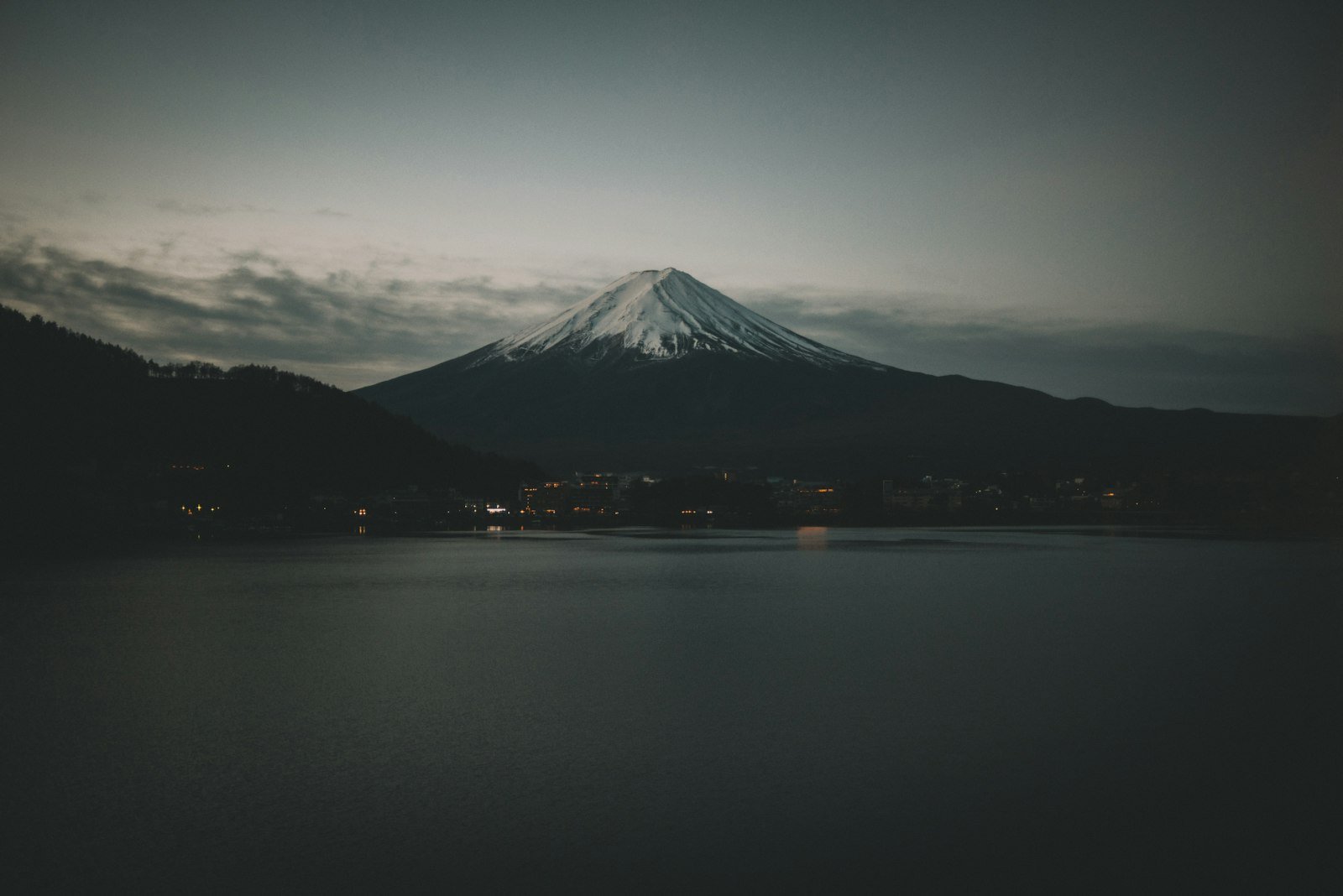 Mount Fuji rising above a dark lake at night in Fujinomiya, Japan, Mount Fuji, Fujinomiya, Japan