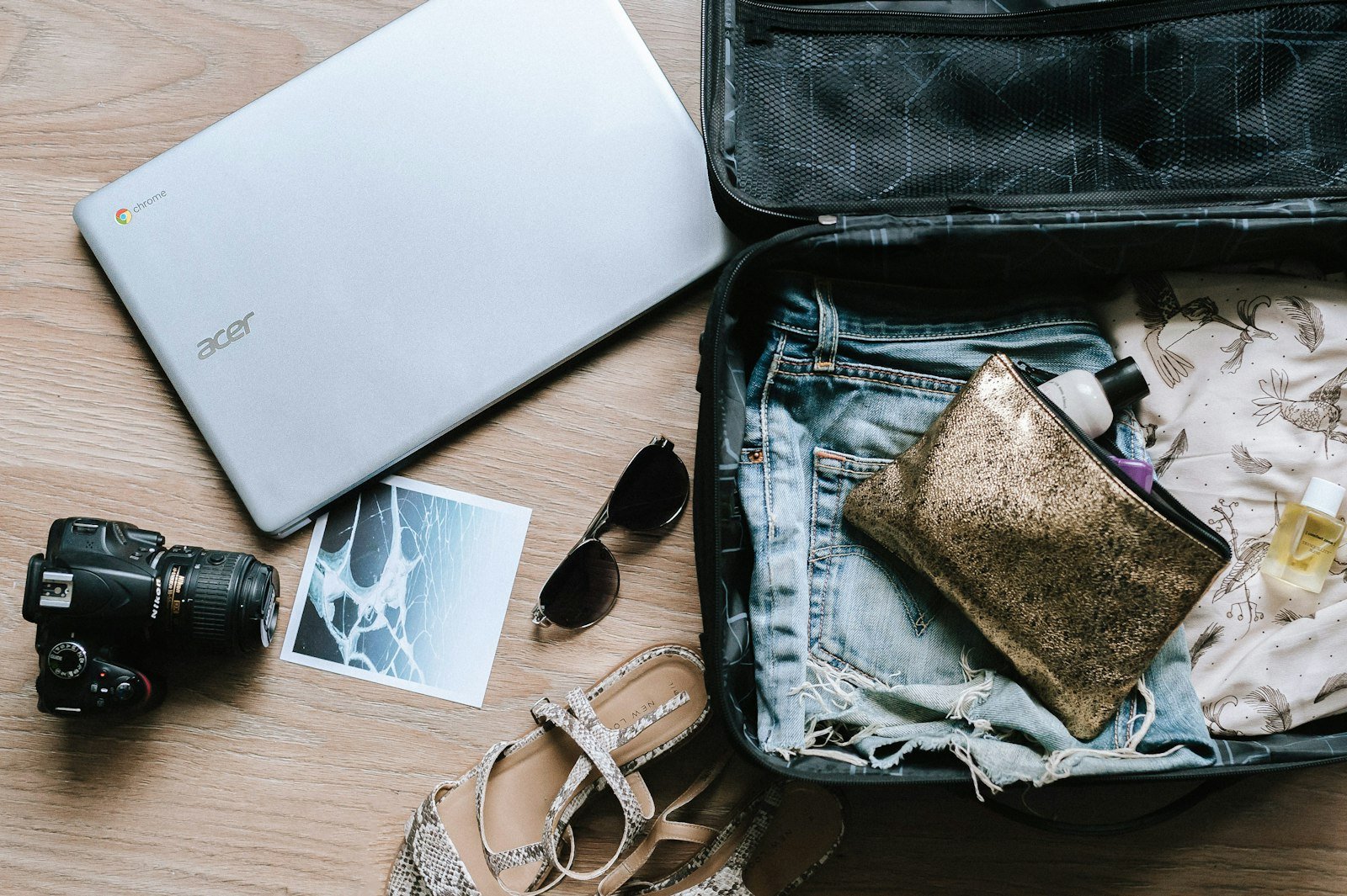 Black DSLR camera near sunglasses and bag
