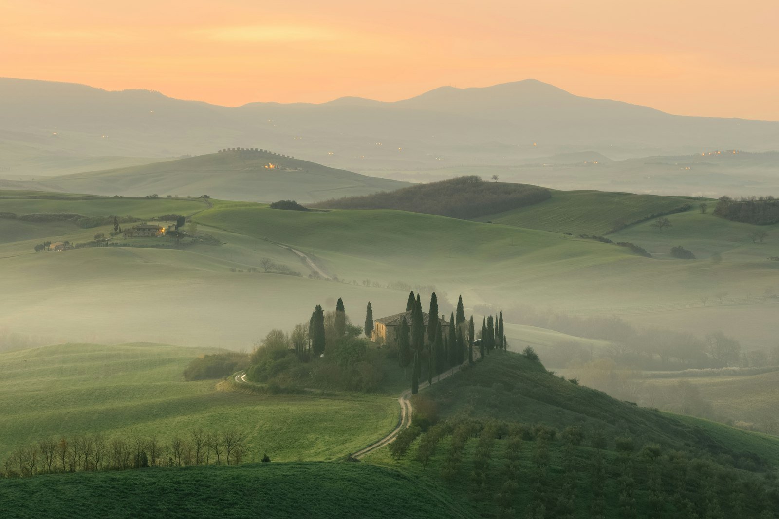 House in middle of grass field, Tuscany, Italy