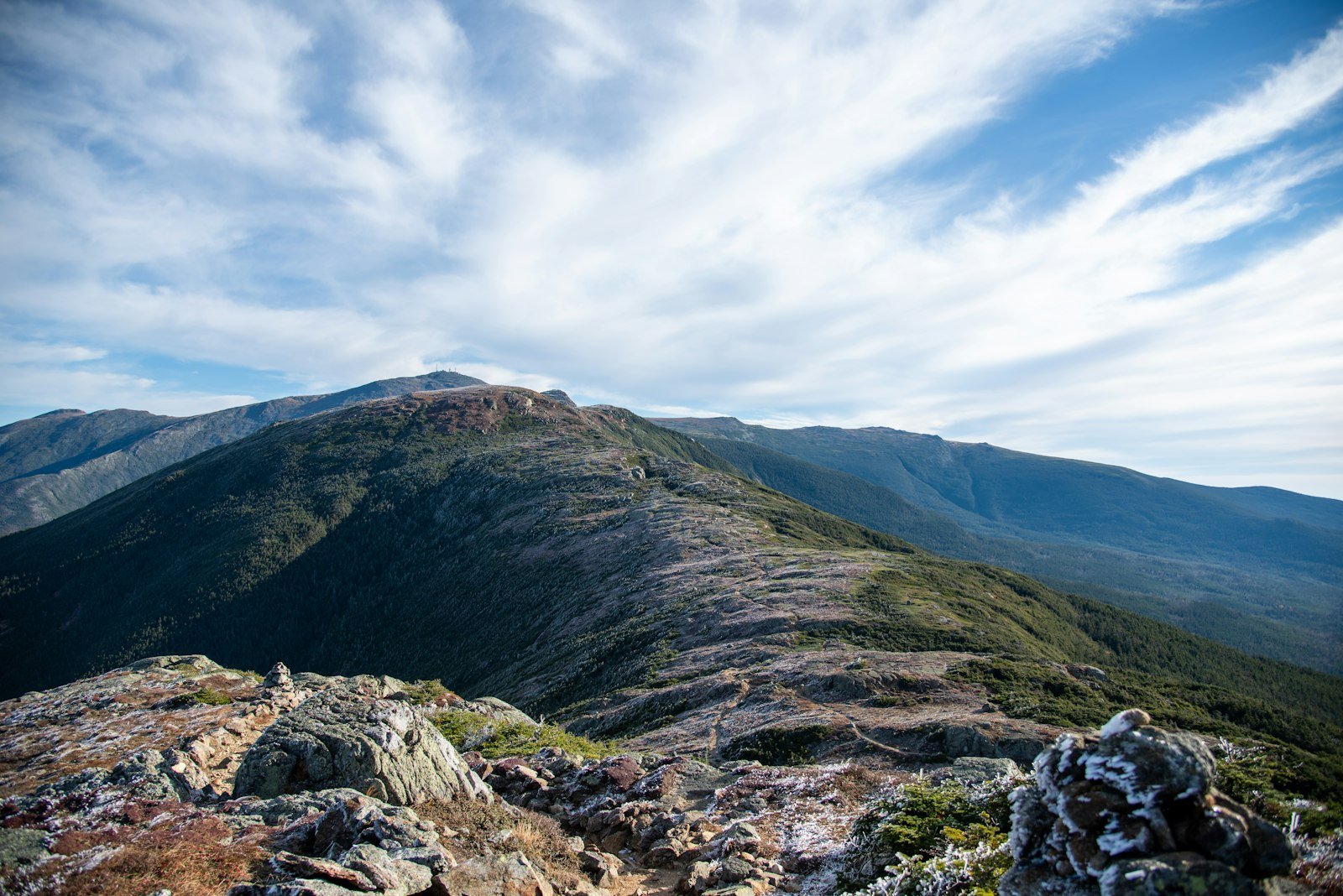 A view of a mountain range from the top of a hill